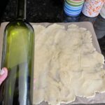 Bottle next to rolled dough