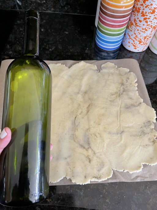 Bottle next to rolled dough