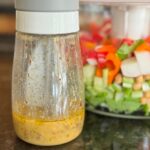 Salad dressing beside fresh vegetables