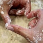 Hands shaping dough with flour