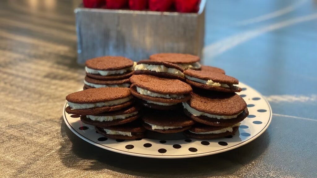 Gluten-Free Whoopie Pies with chocolate cake rounds and creamy white filling arranged on a polka-dot plate.