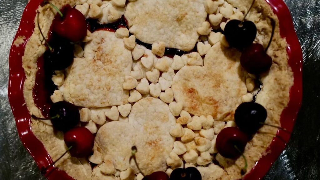 Gluten-Free Cherry Vanilla Pandowdy with a rustic golden pastry topping, heart-shaped crust pieces, and fresh cherries.